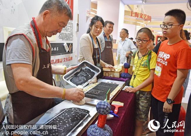 上海字模一厂老师傅在为观众展示中华传统工艺铅活字印刷术。